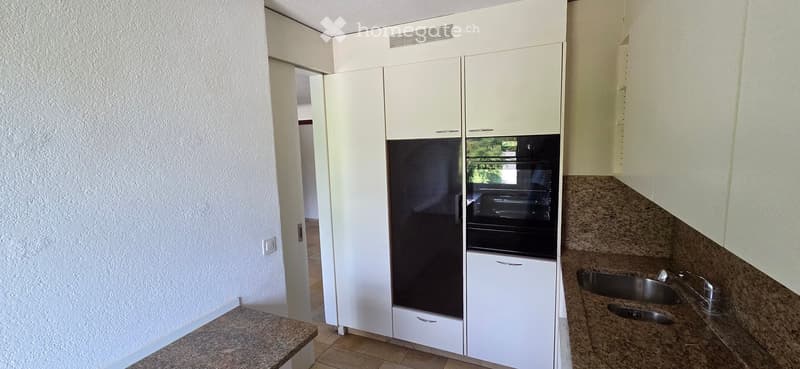 Modern kitchen with white cabinets, stainless steel appliances, granite countertops, and a double sink.