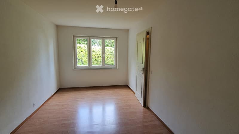 Empty room with wooden flooring, white walls, and a single window with white frame. No furniture or equipment present.