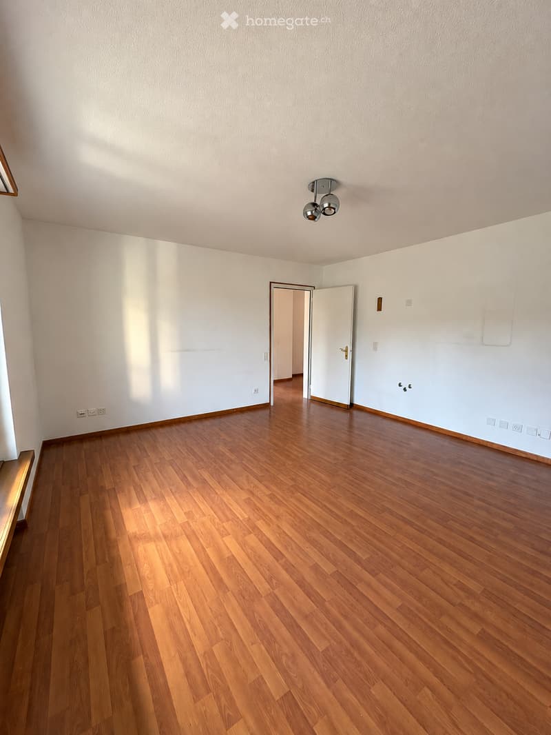 Empty room with wooden flooring, white walls, and a ceiling light fixture. No furniture or equipment is present.