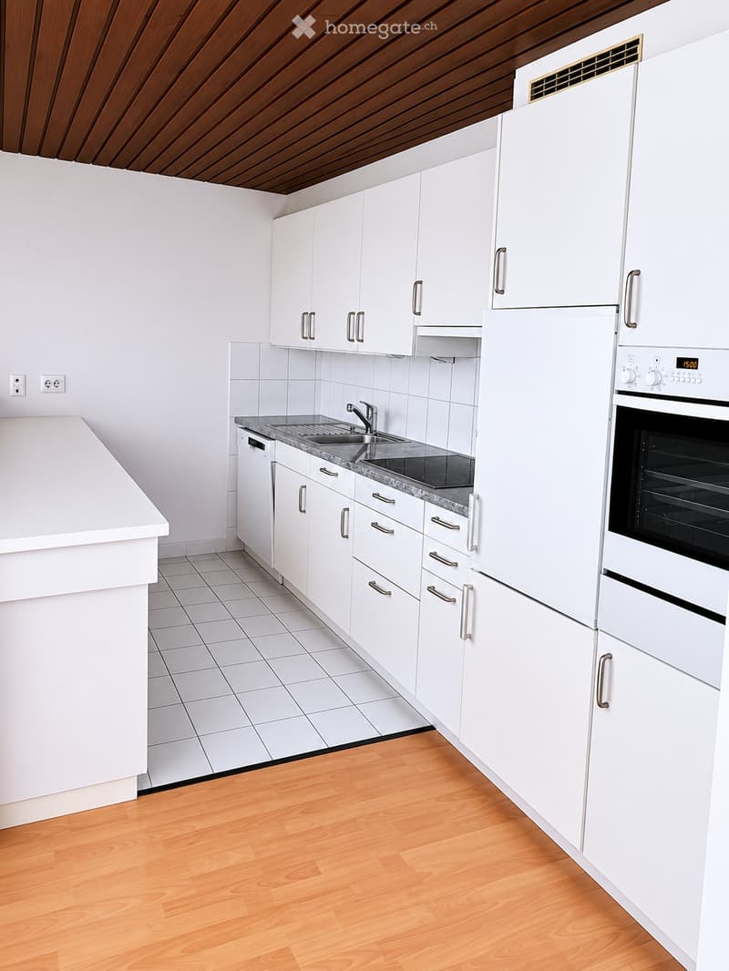 Modern kitchen with white cabinets, stainless steel appliances, and a granite countertop.