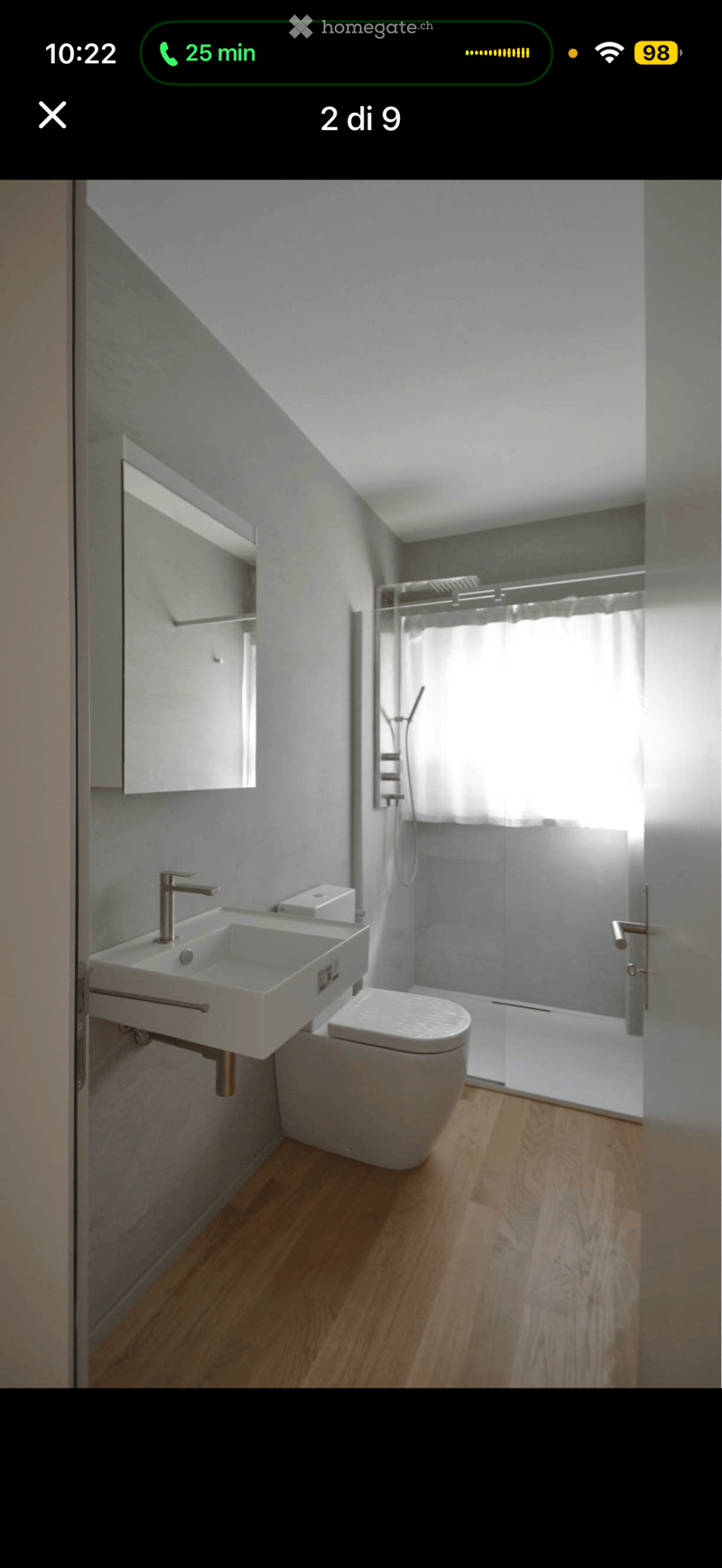 Modern bathroom with a double sink, toilet, glass shower enclosure, and a mirror cabinet.