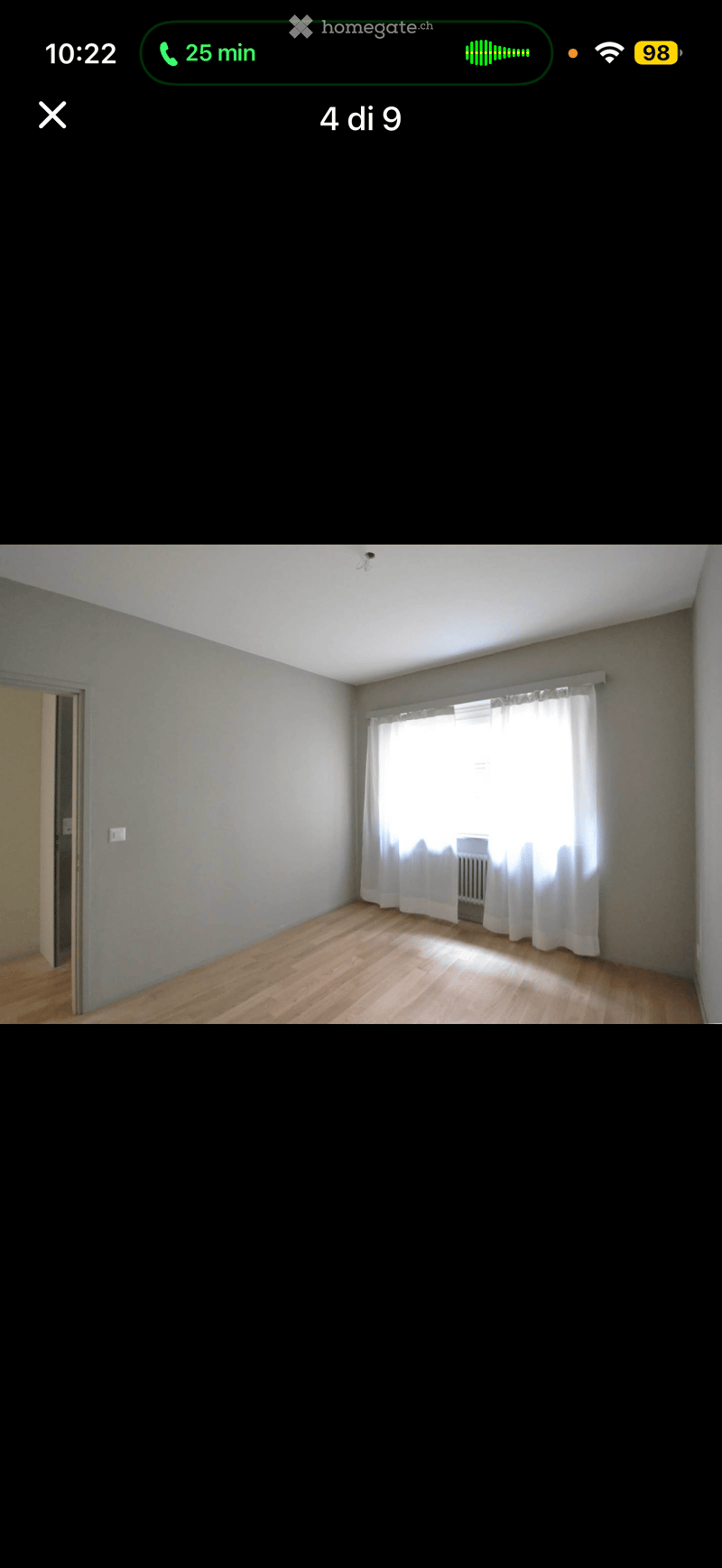 Empty room with wooden flooring, white walls, and a window with white curtains. No furniture or equipment is present.