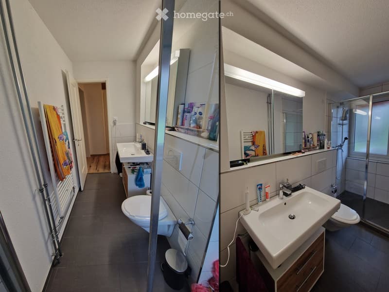 Modern bathroom with a sink, toilet, mirror, and shower. Features include a towel rack with a colorful towel, a small cabinet, and a window providing natural light.