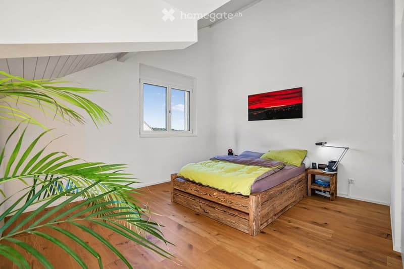 bedroom with wooden bed, wooden floor, white walls, window, nightstand, lamp, painting