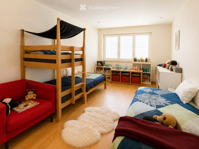 Bright, multi-functional bedroom with a bunk bed, single bed, red sofa, bookshelf, and decorative rug.