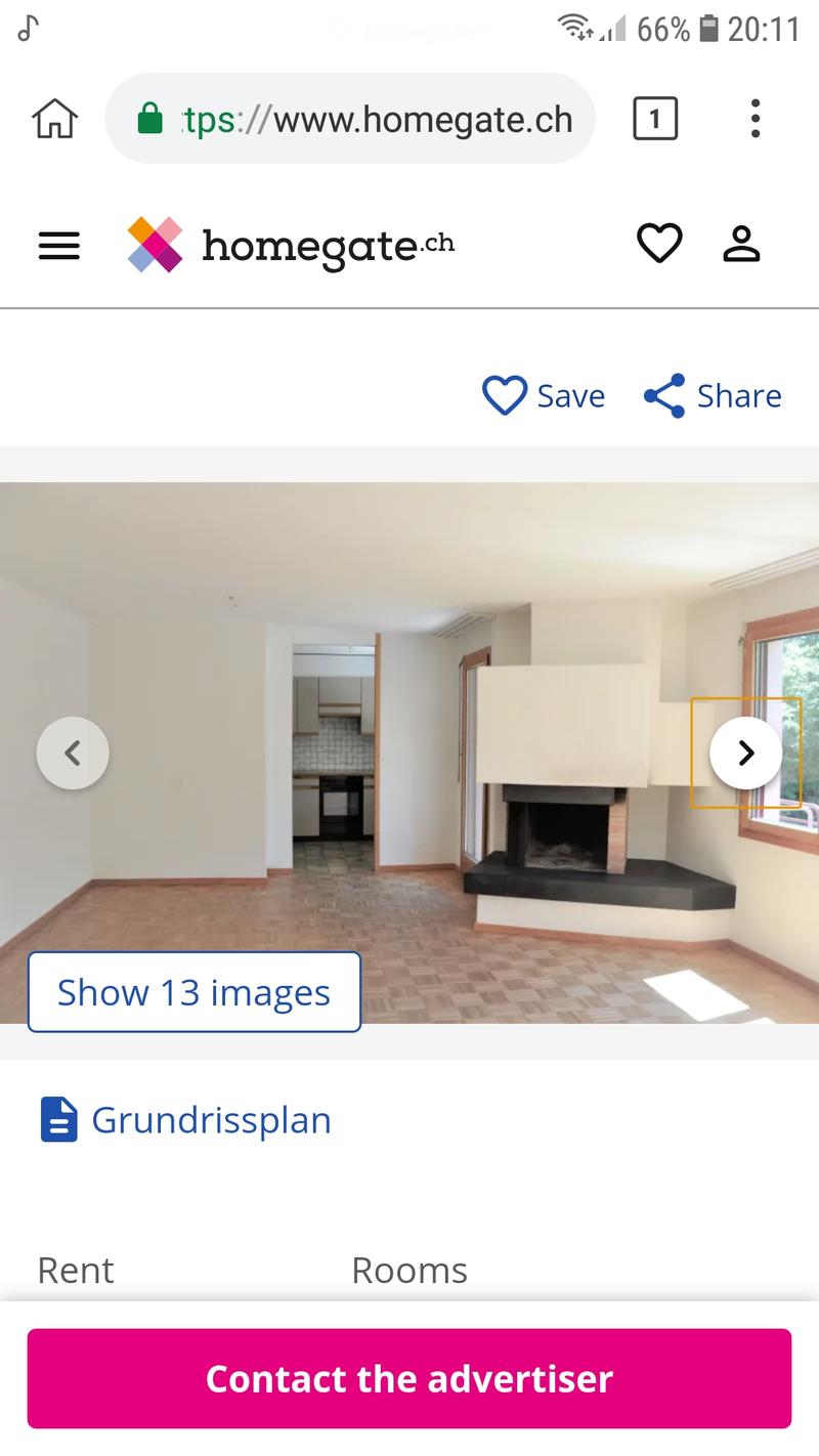 Empty living room with wooden flooring, fireplace, and large windows. No furniture or equipment visible.