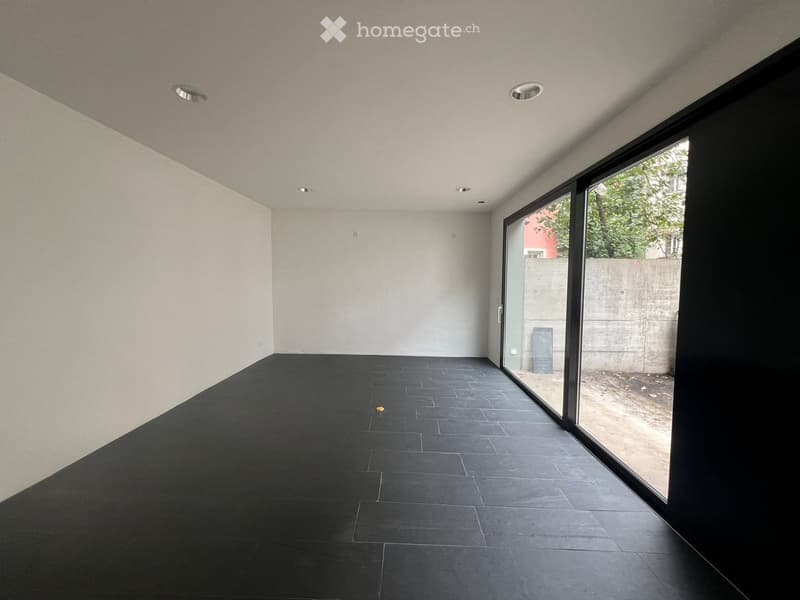 empty room with white walls, black floor, large glass door and windows