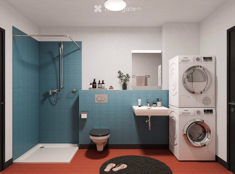 Modern bathroom with blue tiled walls, a shower, toilet, sink, mirror, and stacked washing machine and dryer. Includes a small plant, towels, toiletries, and a rug with flip-flops.