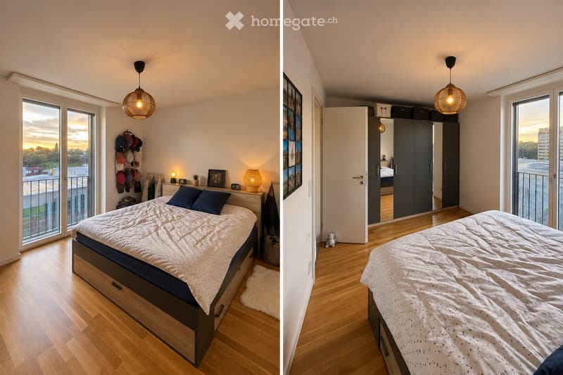 Modern bedroom with wooden flooring, large windows, and a balcony. Features a bed with a white duvet and blue pillows, a nightstand with a table lamp, a hat rack, and a wardrobe with mirrored doors.