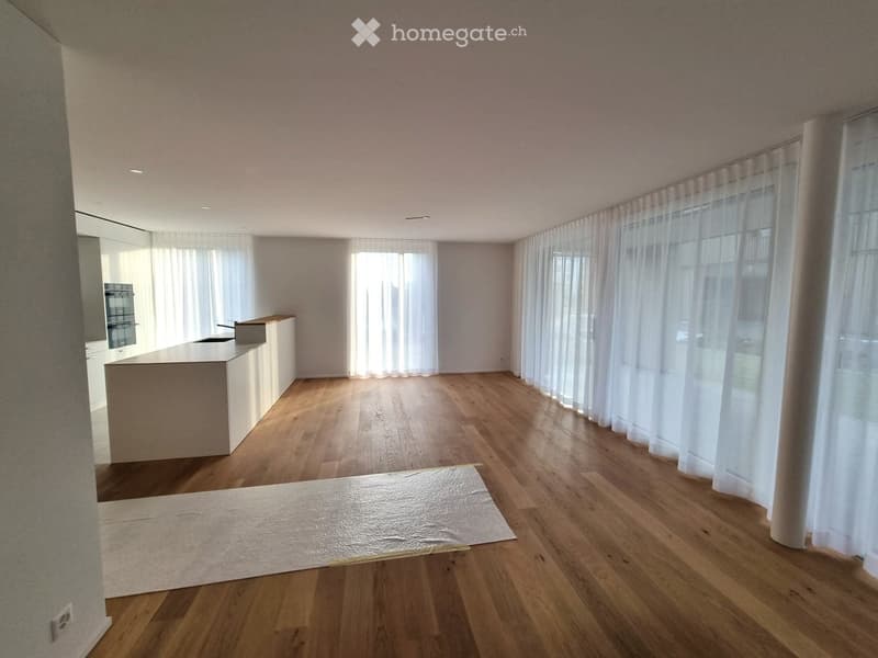 wooden floor, large windows, white curtains, white counter top, empty room