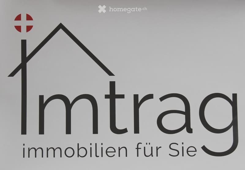 Logo for Imtrag Immobilien, featuring a simple house design with a cross on top, minimalist black and white color scheme, bold uppercase black text.