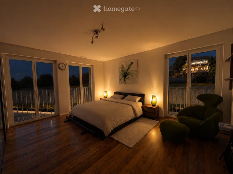 Modern bedroom with hardwood floors, large windows, a bed with white bedding, nightstands with lamps, a green chair, and a painting on the wall.