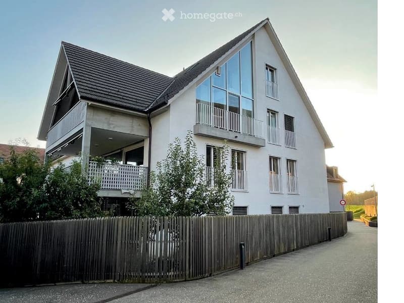 Modern two-story house with white exterior, large windows, and balconies.