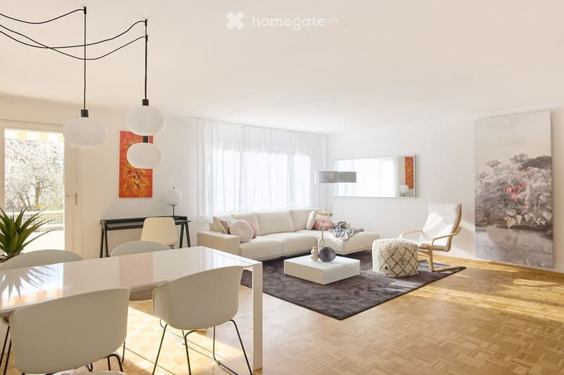 Modern living room with white walls, wooden flooring, large windows, and a mix of contemporary furniture including a white sofa, coffee table, dining table, chairs, and a floor lamp.