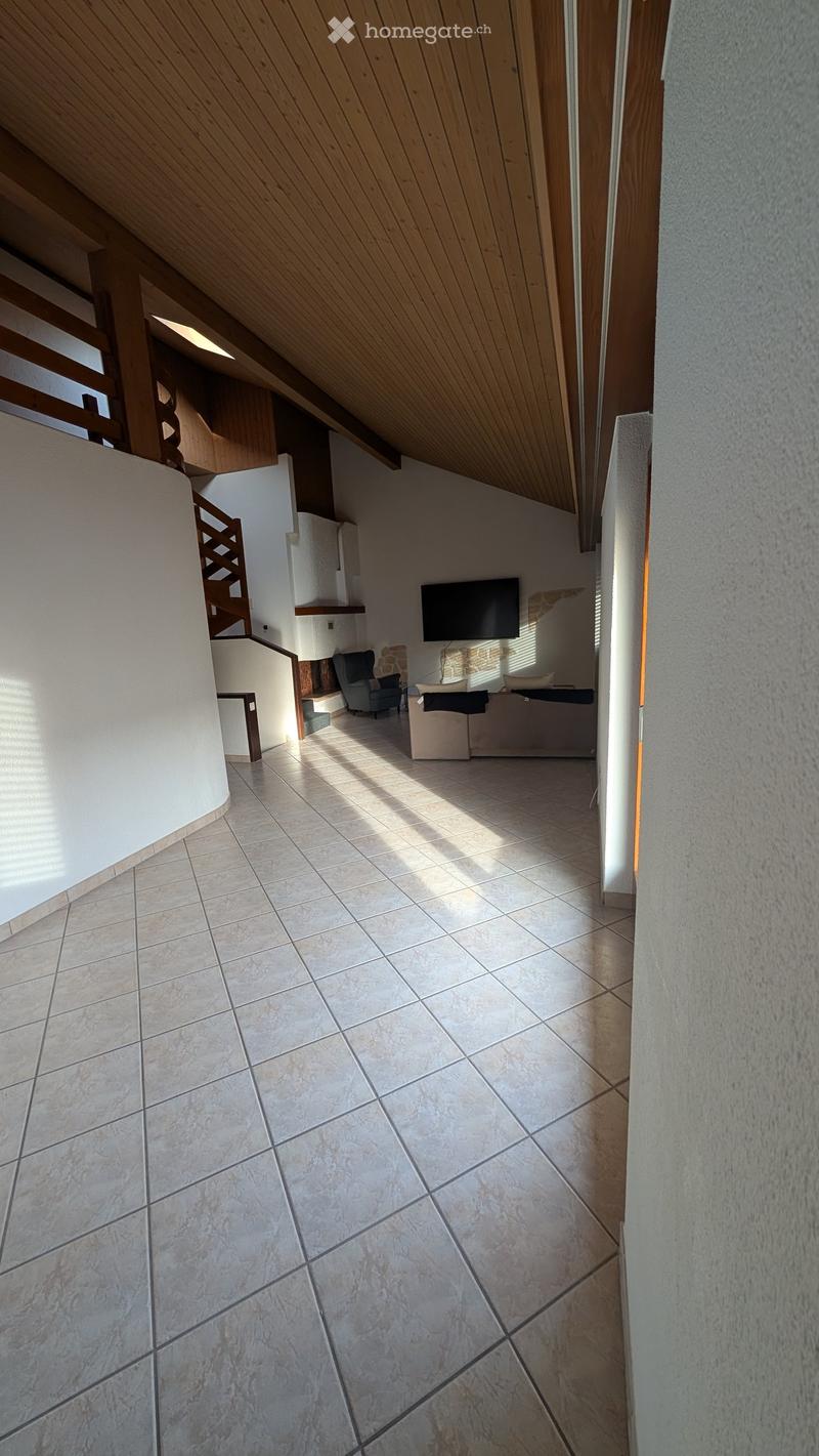 empty room, tiled floor, tv on wall, fireplace, armchair, sofa, open staircase