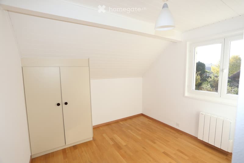 Unfurnished Room. Empty room with white walls, wooden floor, a wardrobe, a window, and a radiator.