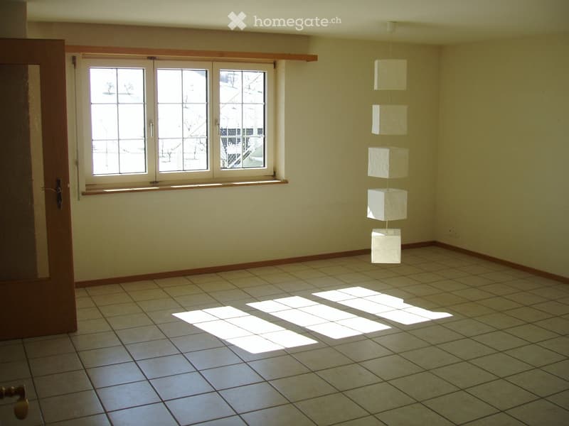 Empty room with tiled floor, large windows, and a hanging paper lantern decoration.