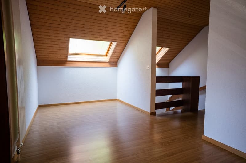 Empty room with wooden flooring, white walls, and skylight windows. No furniture or equipment present.