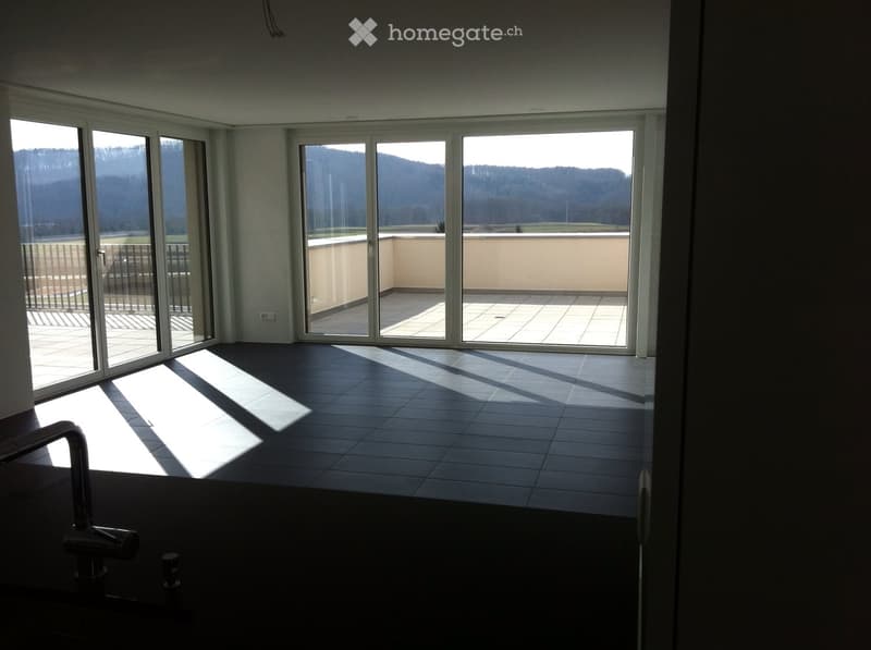 Empty room with large sliding glass doors leading to a balcony, tiled floor, and natural light from the windows.
