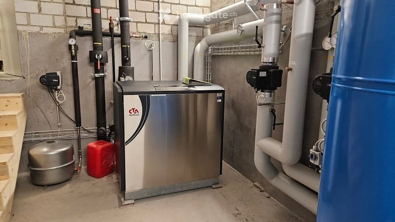 Utility room with a water heater, water softener, storage tank, and various pipes and valves.