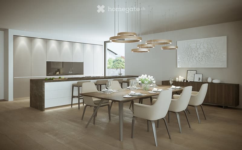 The image shows a modern, open-concept kitchen and dining room. The kitchen features white cabinets, a dark countertop, and a built-in dishwasher. The dining area has a large wooden table with beige upholstered chairs, and several pendant lights hang abov