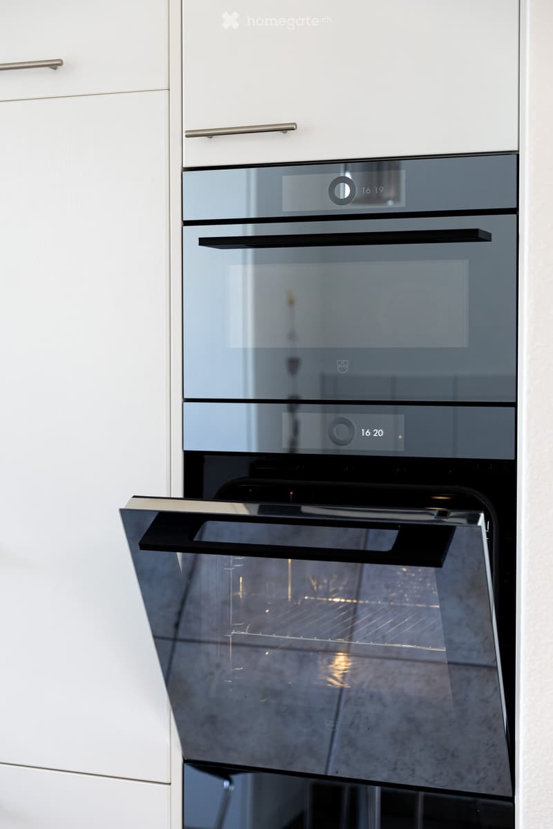 Modern kitchen with a built-in oven featuring multiple compartments and digital displays.