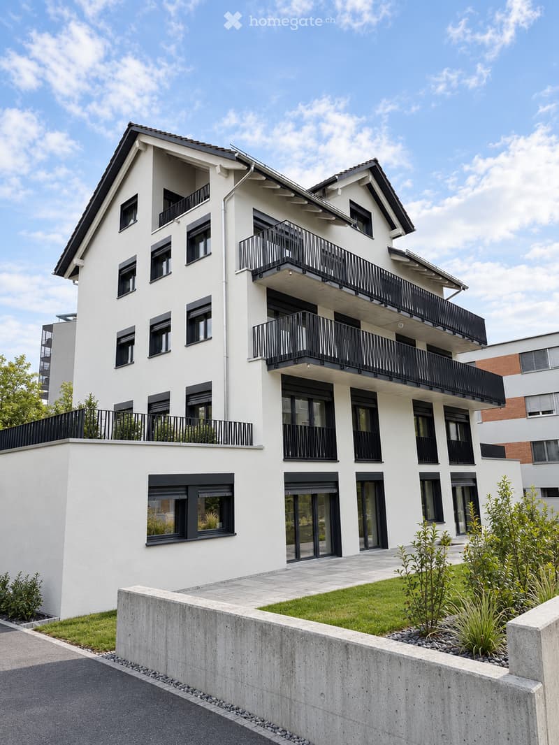 Modern two-story residential building with white facade, black railings, multiple balconies, and contemporary design.