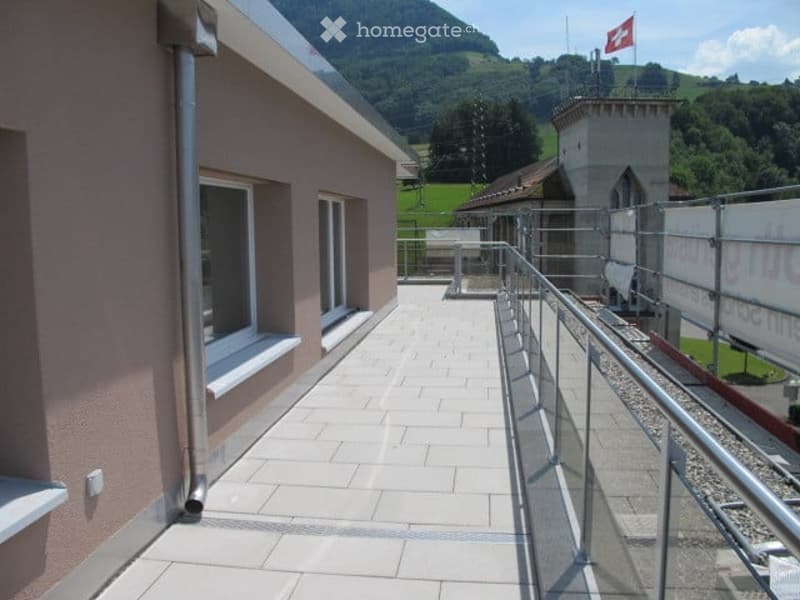 Balcony with tiled floor, metal railing, and scenic mountain view in the background.