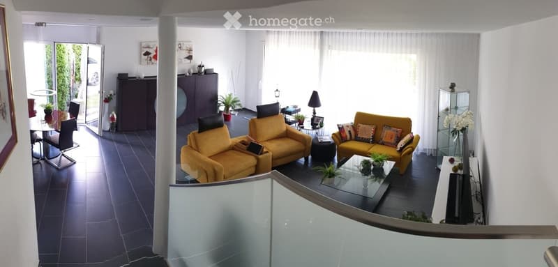 Bright living room with yellow sofas, glass coffee table, dining area with chairs and table, decorative vases, and artwork on walls.