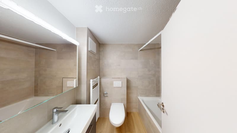 Modern bathroom with a sink, toilet, bathtub, and built-in shelves. Features a large mirror and a sleek faucet.