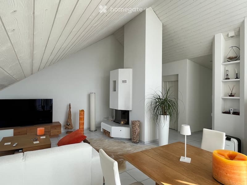 Modern living room with white walls, wooden furniture, fireplace, large TV, and decorative items.