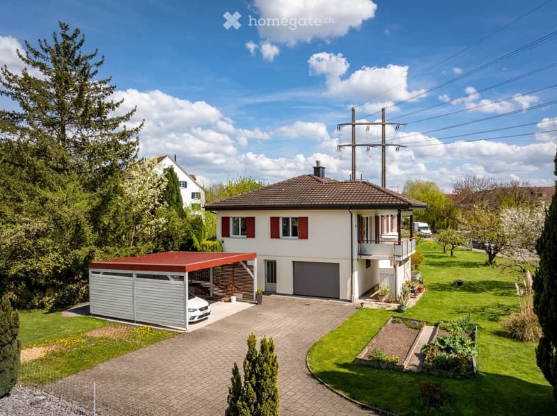 Single-family house with a garage, covered parking area, and well-maintained garden.