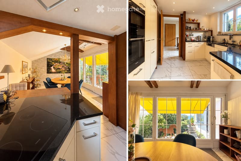 The image shows a modern, well-furnished living and dining area with a sleek kitchen. The living area features a sofa, a dining table with chairs, a chandelier, and a floor lamp. The kitchen has white cabinets, a built-in oven, a sink with a faucet, and a