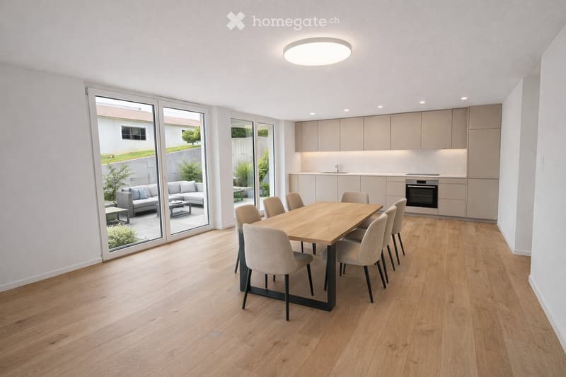 Open-plan dining and living area with light wood flooring, modern kitchen cabinets, dining table with six chairs, grey sofa, and large sliding glass doors leading to a patio.