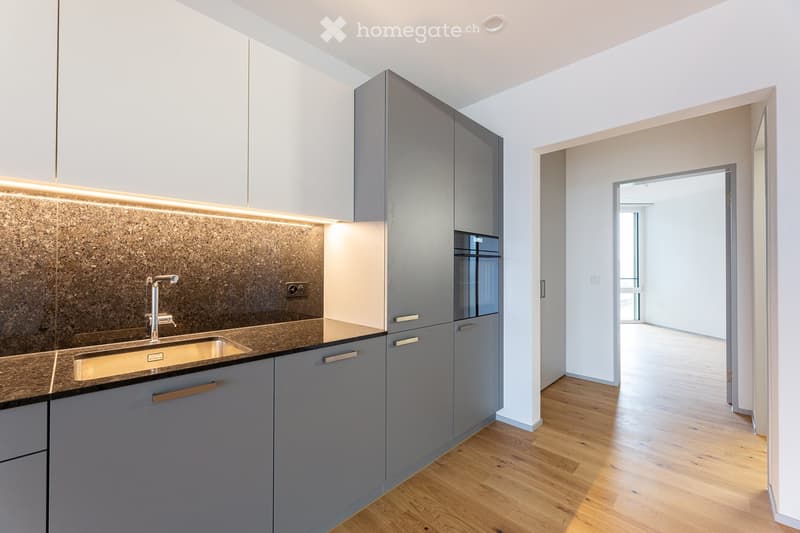 kitchen with grey cabinets, granite countertop, stainless steel sink, built-in oven, wooden floor