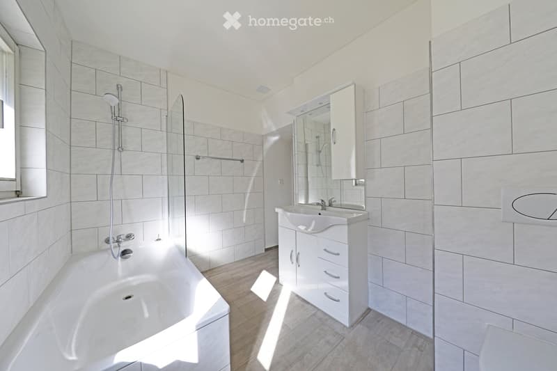 modern bathroom, white tiles, bathtub, shower, sink, mirror, wooden floor, white cabinet