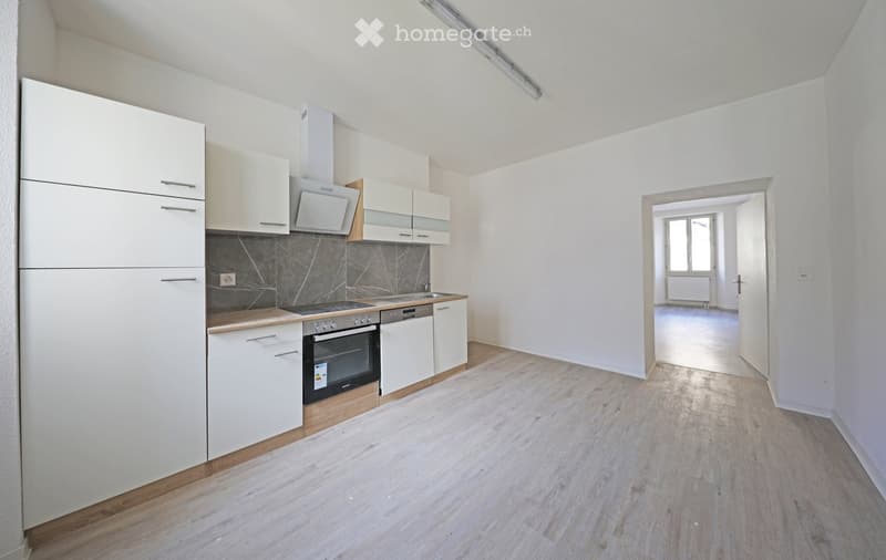 modern minimalist kitchen with white cabinetry, wooden flooring, built-in appliances, bright white walls