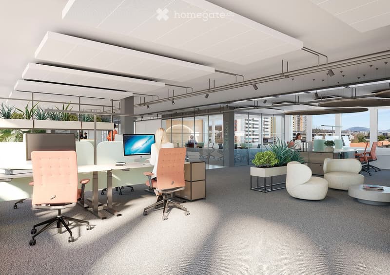 Modern office space with desks, chairs, screens, and plants, featuring large windows and a contemporary design.