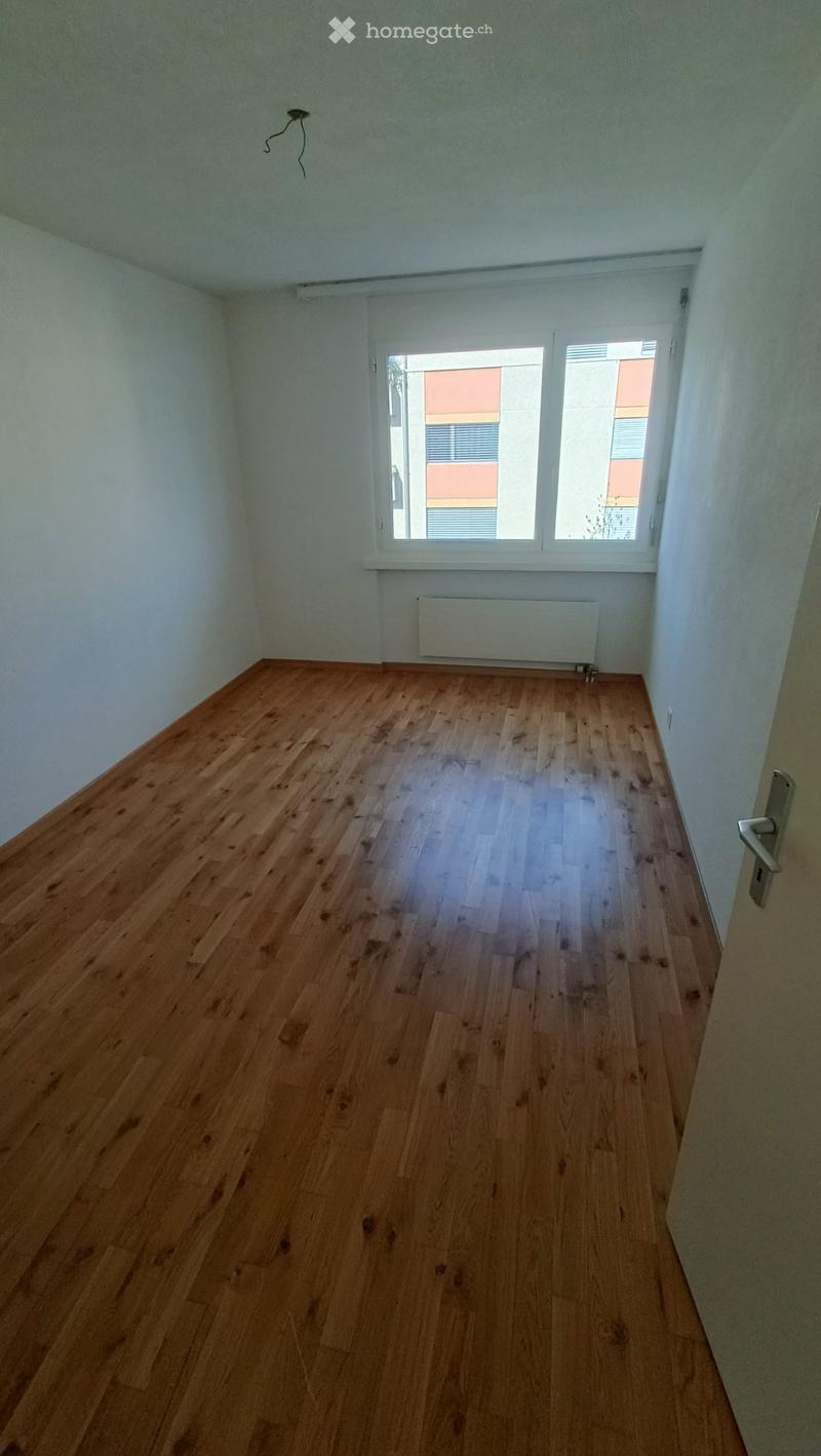 Empty room with wooden flooring, white walls, and a window with blinds. No furniture or equipment is present.