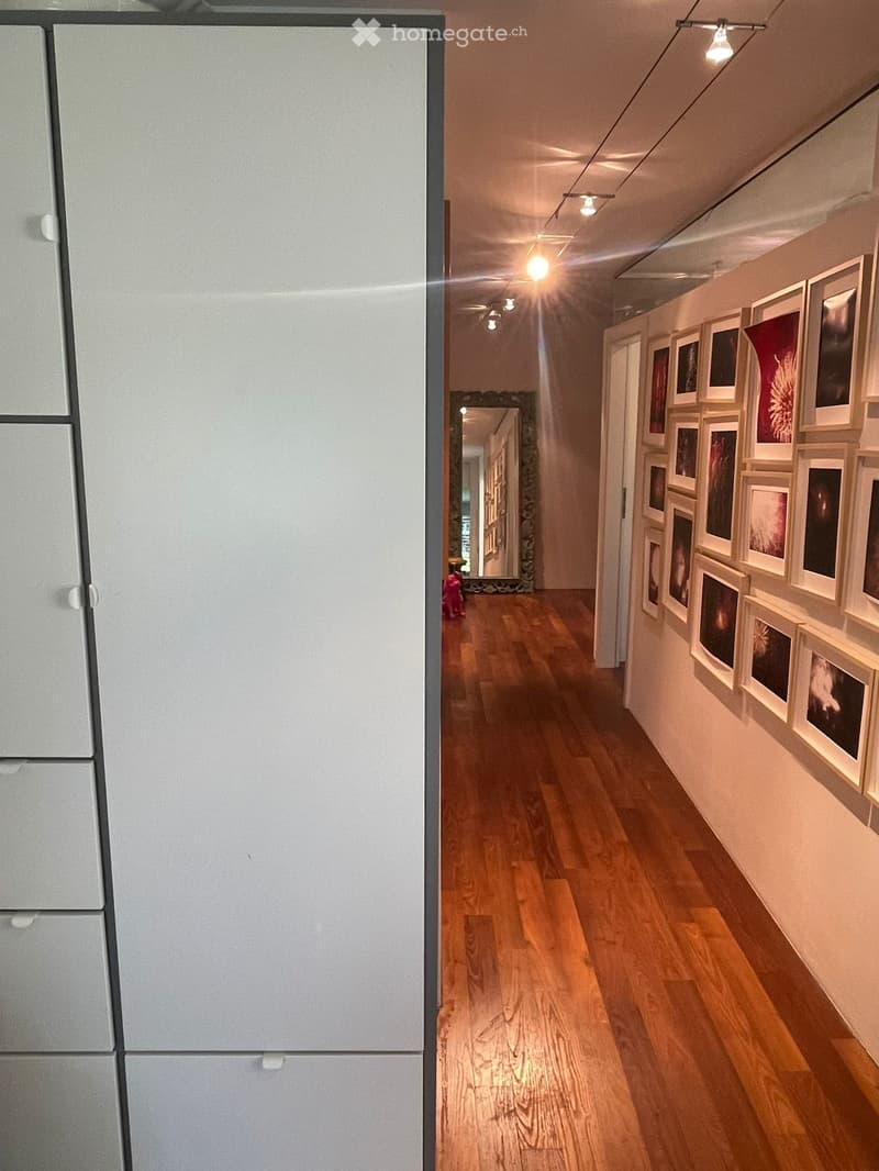 wooden floor, white wardrobe, white drawers, mirror, wall gallery, lights