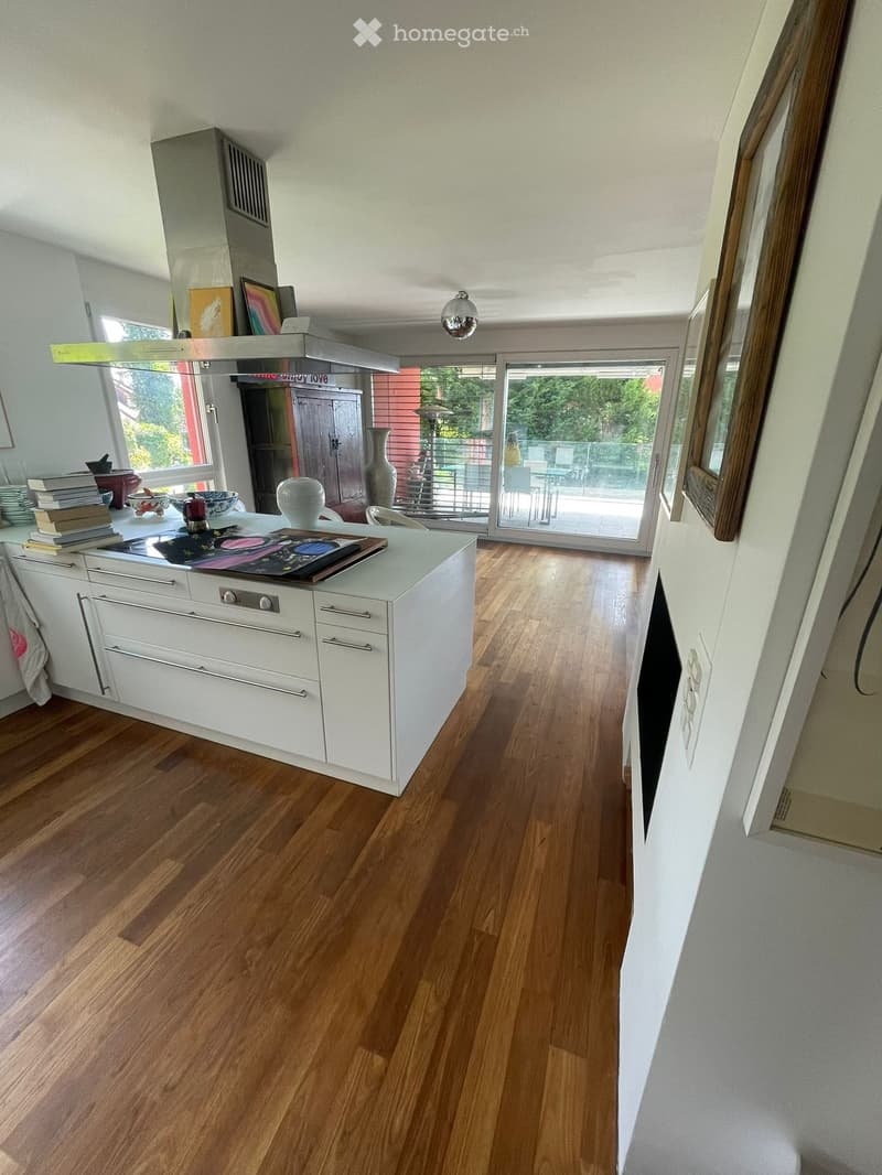 kitchen island with stove and dishwasher, white cabinets, hardwood floors, open balcony