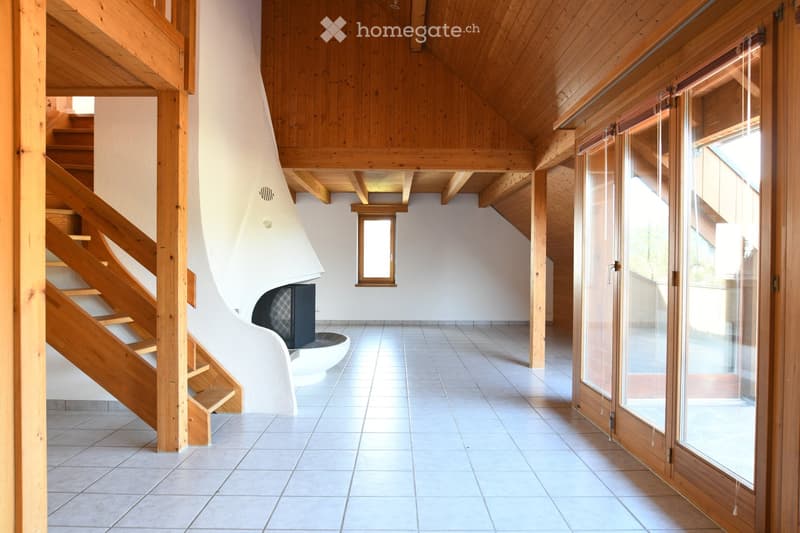 Modern hallway with wooden staircase, fireplace, large windows, and exposed wooden beams.