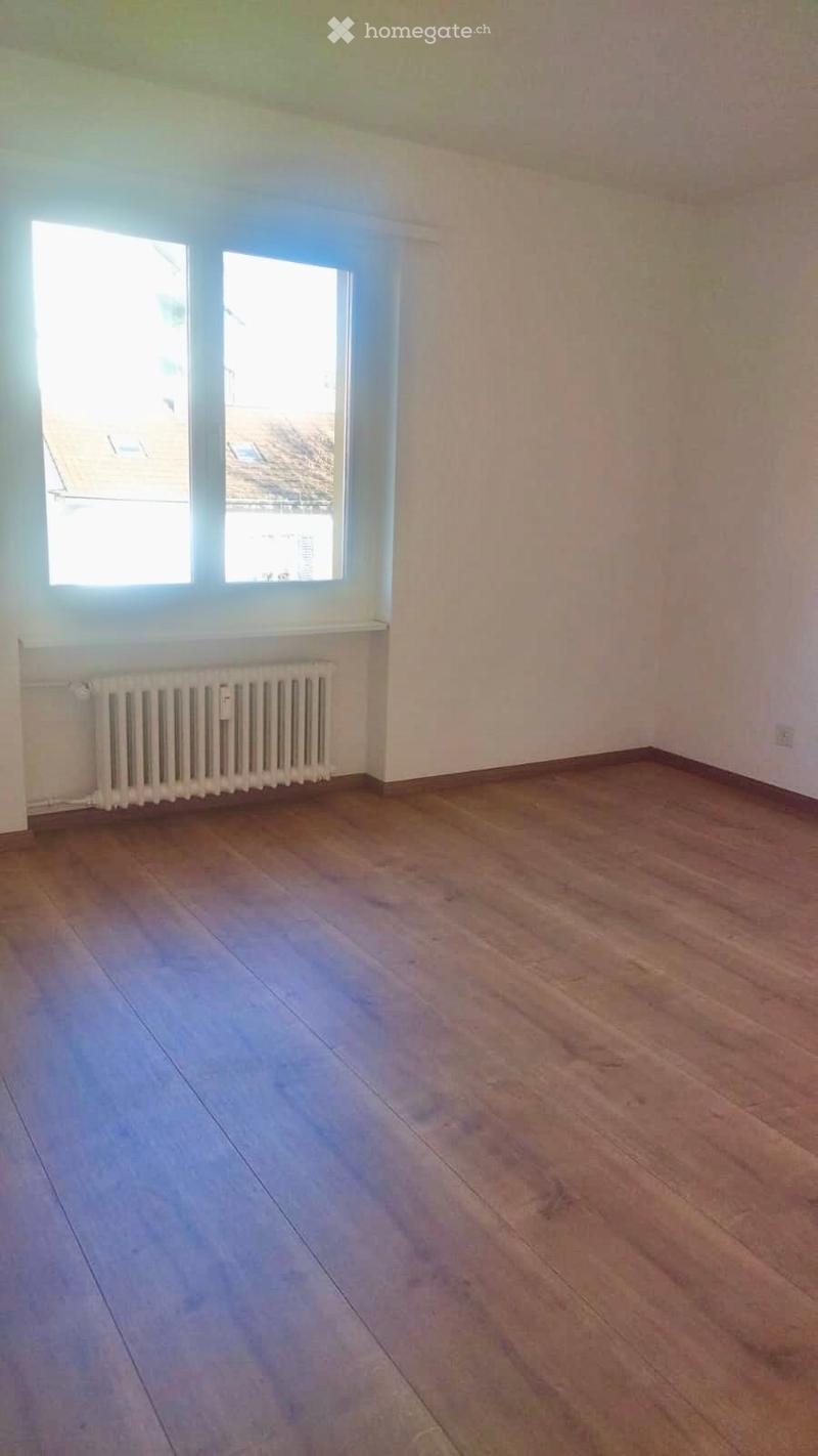 Empty room, wooden floors, white walls, windows, radiator
