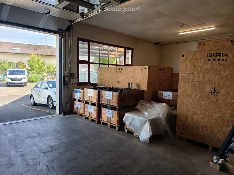 {"visible_features": ["Garage"], "type": "Garage", "objects": [], "description": "Garage with large windows, wooden crates, and covered machinery. Two cars are parked outside.", "localized_descriptions": {"EN": "Garage with large windows, wooden crates, a
