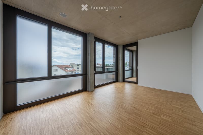 open plan room with wooden floors, large windows and a balcony