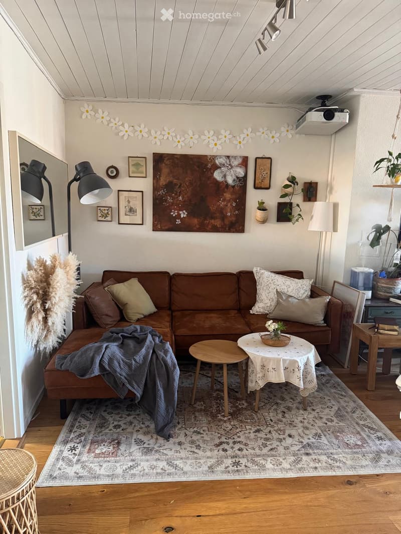 Cozy living room with a brown sectional sofa, wooden coffee table, side table, floor lamp, and decorative items.