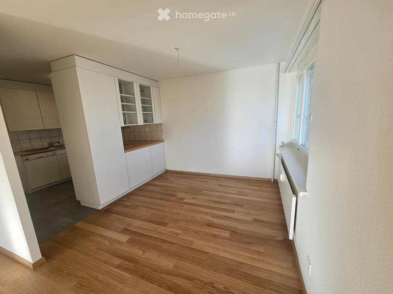 Empty room with wooden flooring, white walls, and built-in cabinets. No furniture or appliances are present.