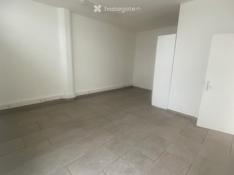 Empty room with white walls, tiled floor, and a single white closet door.
