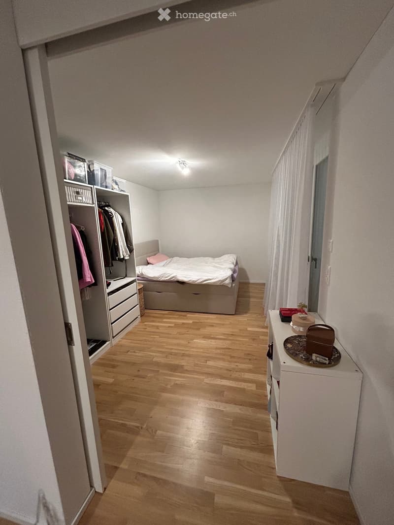 Bedroom with bed, wardrobe, drawers, wooden floor