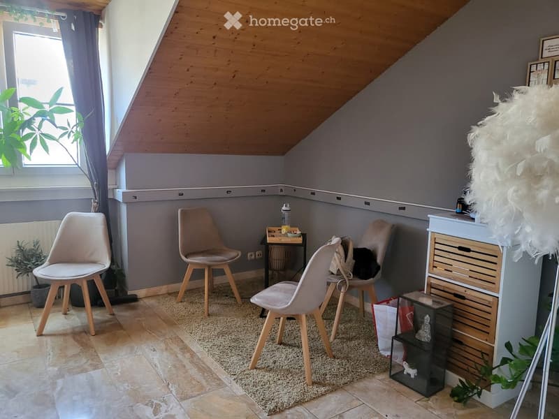 small room with wooden ceiling, beige carpet, beige chairs, white cabinet, potted plants
